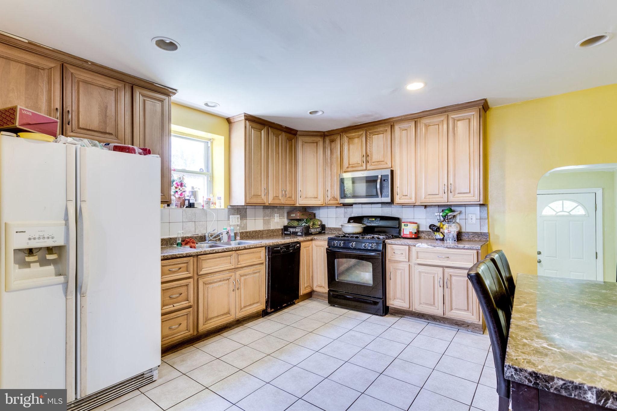 14001 Livingston Road Clinton, MD 20735 - Photo 10 of 28 a kitchen with granite countertop a refrigerator stove top oven dining table and chairs