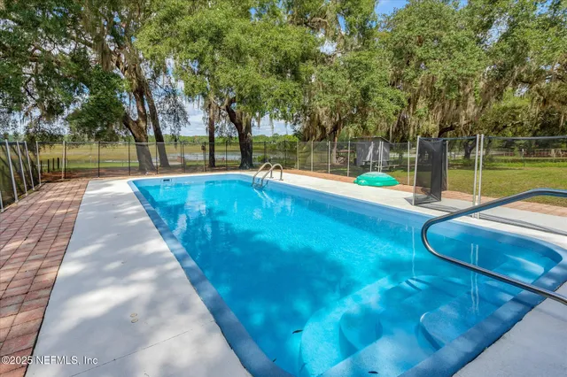 a view of a house with pool and a yard