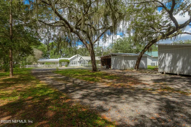 a view of a street with a barn in the background