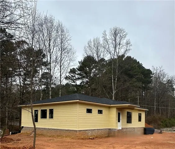 a front view of house with yard and trees in the background