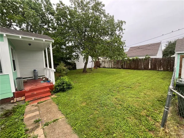 a view of a house with a big yard and large trees