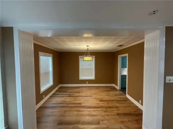 a view of an empty room with window and bathroom