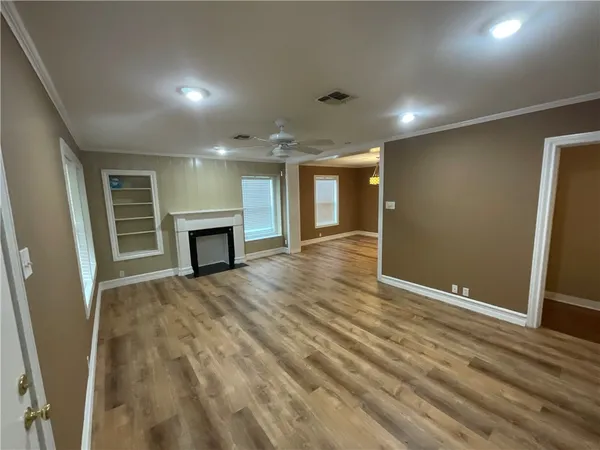 an empty room with wooden floor and fireplace