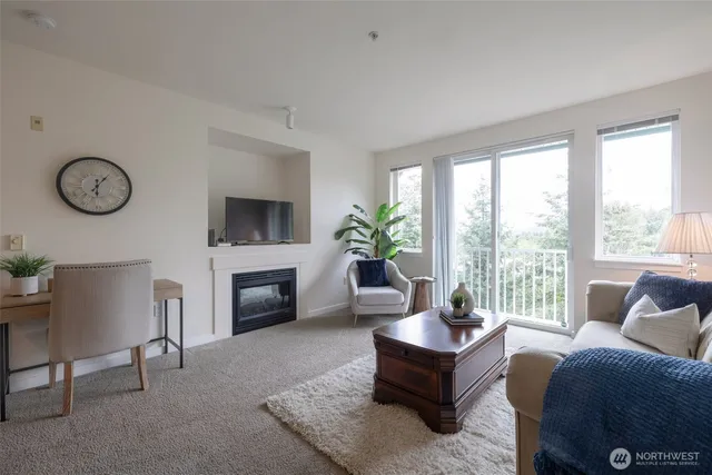 a living room with furniture a fireplace and a large window