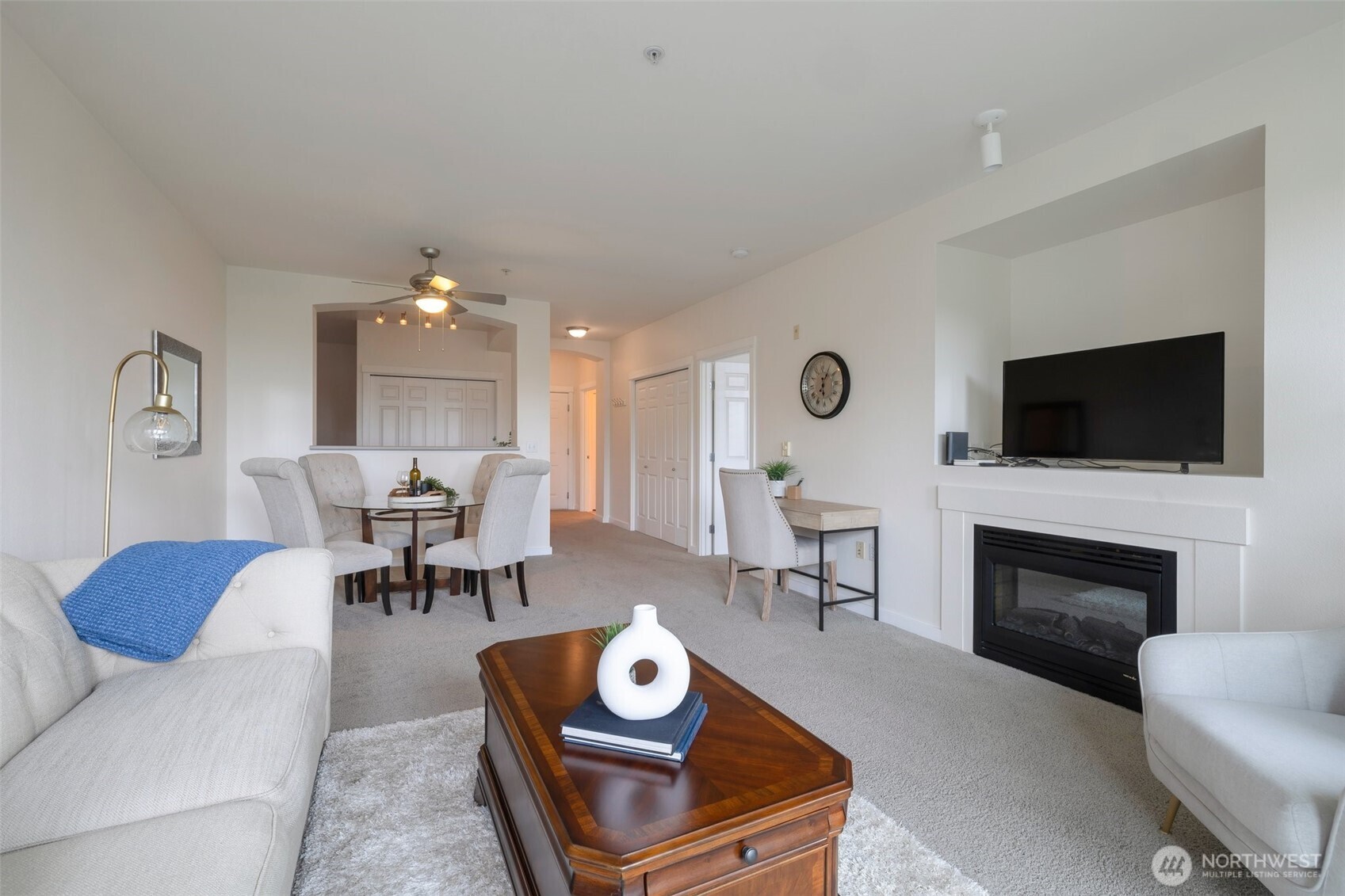 13301 Southeast 79th Place, Unit B402 Newcastle, WA 98059 - Photo 7 of 25 a living room with furniture a fireplace and a flat screen tv