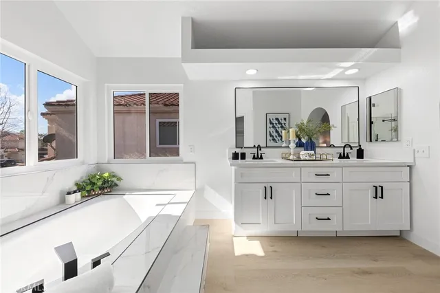 a bathroom with a tub sink and mirror