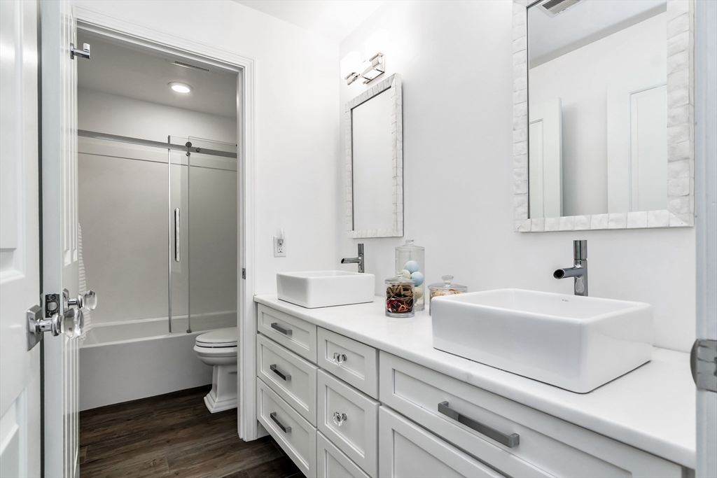 6 Summer Street, Unit D Manchester, MA 01944 - Photo 24 of 31 a bathroom with a double vanity sink mirror and bathtub