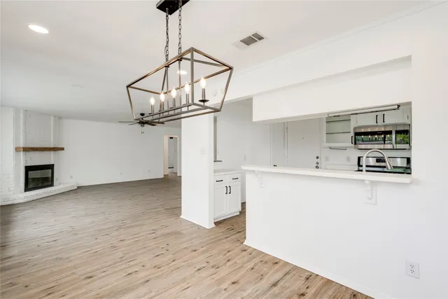 a kitchen with stainless steel appliances a wooden floor a stove and a refrigerator