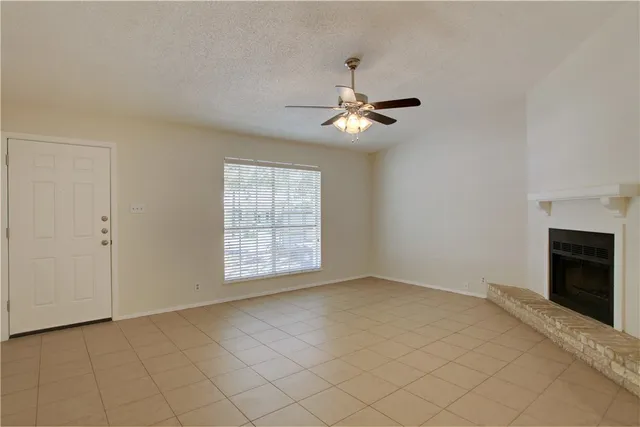 a view of an empty room with a fireplace and a window