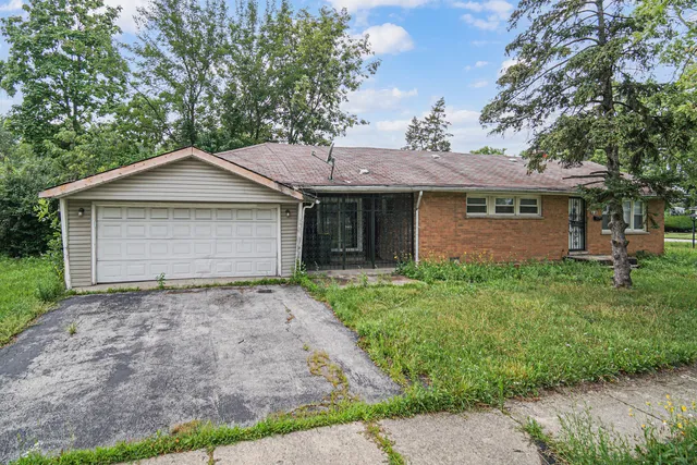 a front view of a house with a garden and yard