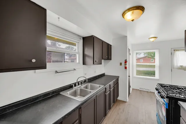 a kitchen with a sink appliances and a window