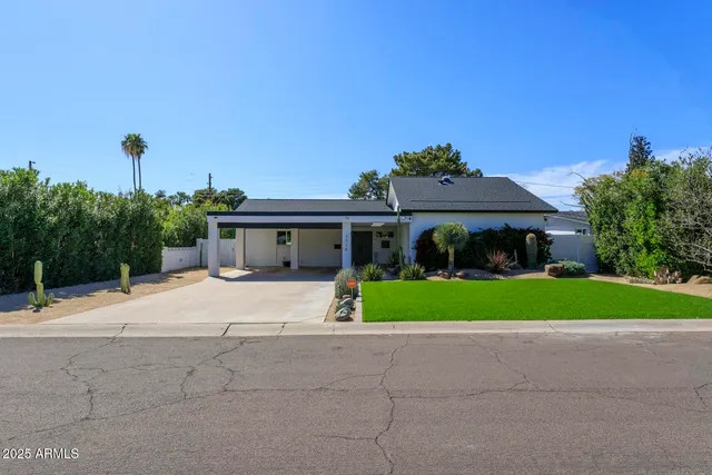 a front view of a house with a garden and yard
