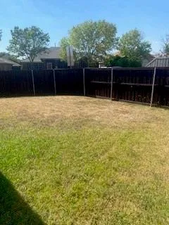 a view of house with a backyard