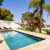 a view of a swimming pool with a yard and palm trees