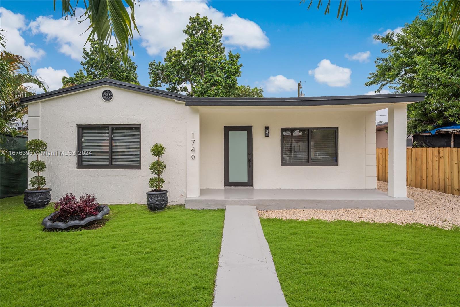1740 Northwest 53rd Street Miami, FL 33142 - Photo 22 of 25 a front view of a house with garden