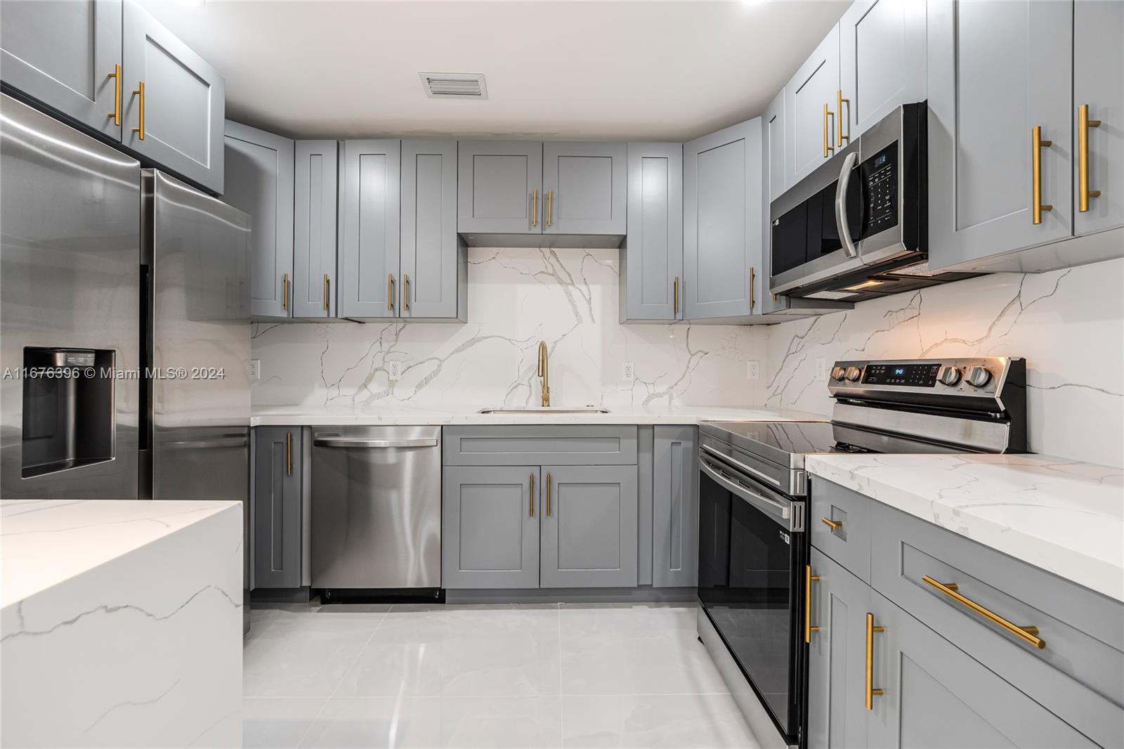 1740 Northwest 53rd Street Miami, FL 33142 - Photo 5 of 25 a kitchen with stainless steel appliances granite countertop a sink and a stove