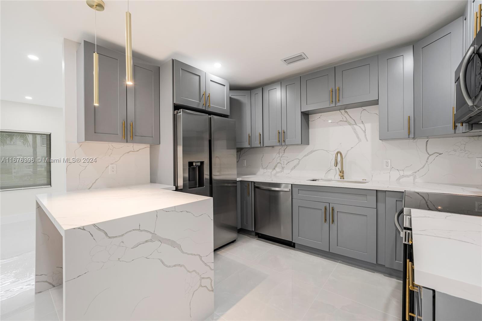 1740 Northwest 53rd Street Miami, FL 33142 - Photo 6 of 25 a kitchen with a sink a refrigerator and a stove top oven