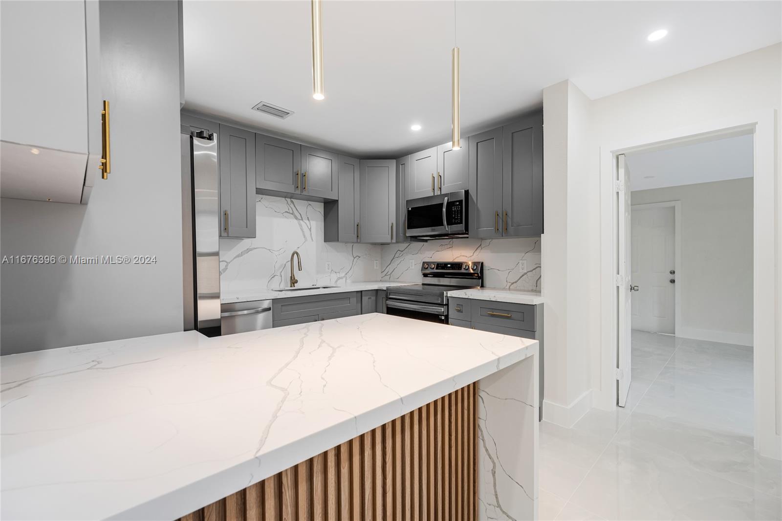 1740 Northwest 53rd Street Miami, FL 33142 - Photo 7 of 25 a kitchen with stainless steel appliances a refrigerator sink and microwave