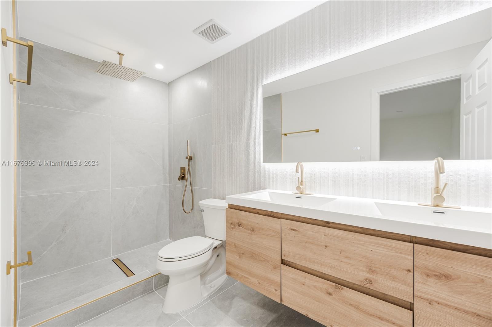 1740 Northwest 53rd Street Miami, FL 33142 - Photo 10 of 25 a bathroom with a granite countertop sink toilet a mirror and shower