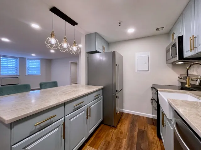 a kitchen with stainless steel appliances granite countertop a sink a refrigerator and a stove