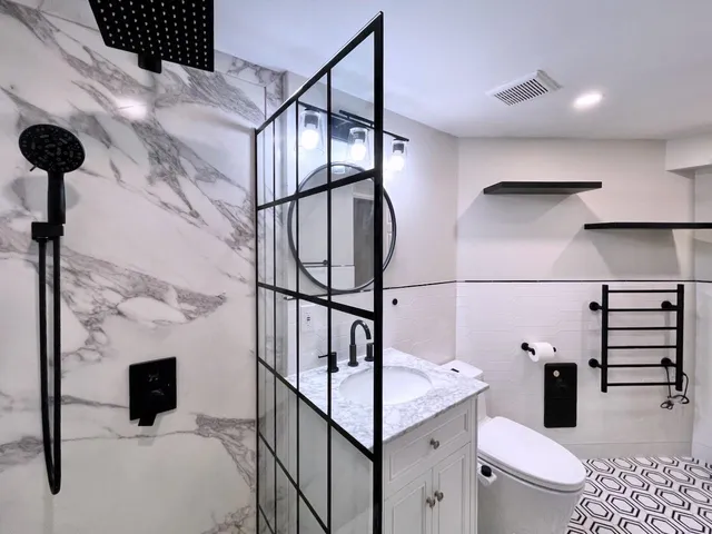 a bathroom with a sink a toilet and shower