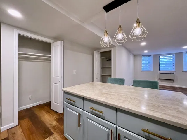 a view of a room with wooden floor and chandelier