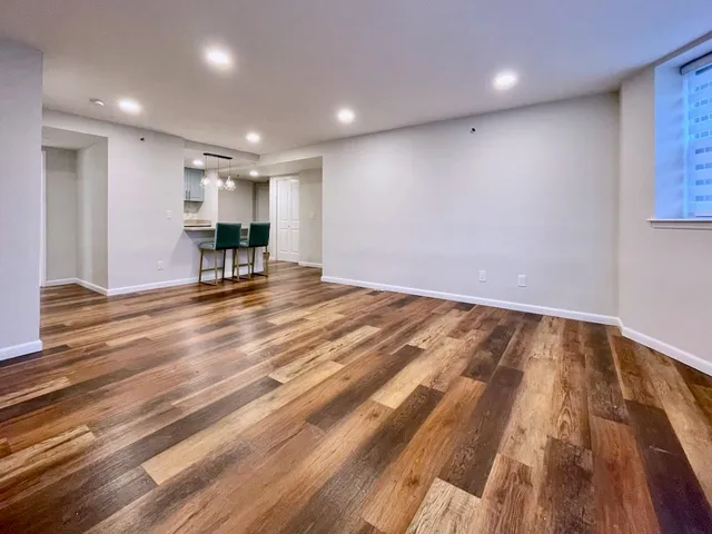 a view of an empty room with wooden floor