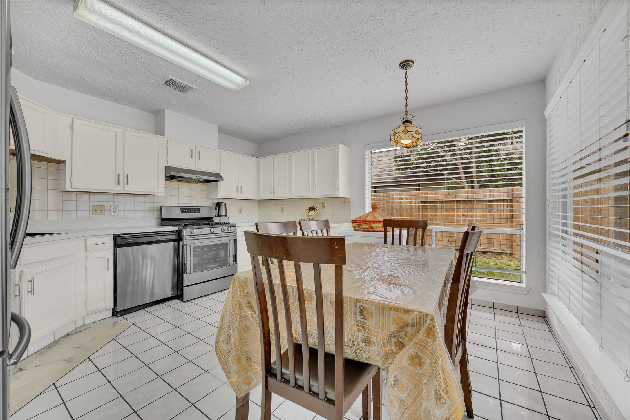 15619 Beechnut Street Houston, TX 77083 - Photo 12 of 29 Beautifully updated kitchen featuring granite countertops, beige cabinetry with silver hardware, and stainless-steel appliances.