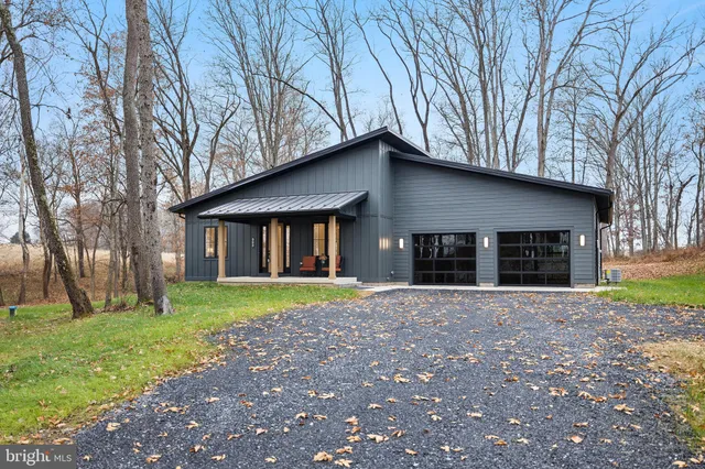 a front view of a house with a yard and trees