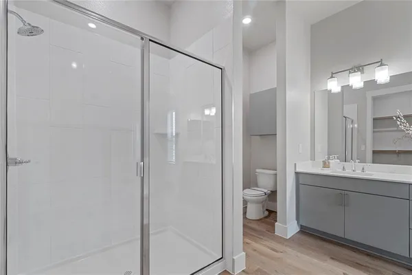 a bathroom with a double vanity sink toilet and shower
