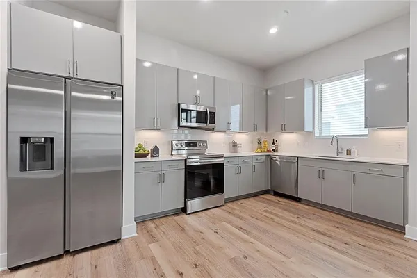 a large kitchen with a refrigerator a center island a stove a sink cabinets and a refrigerator