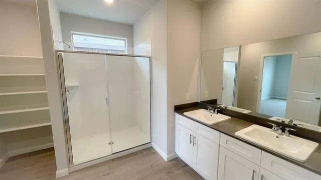 an empty room with wooden floor chandelier fan and windows
