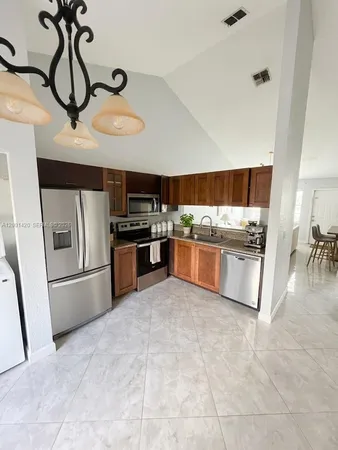 a kitchen with stainless steel appliances granite countertop a refrigerator and a sink