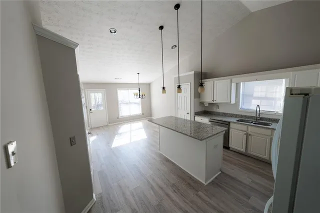 a kitchen with stainless steel appliances granite countertop a stove a sink and a refrigerator