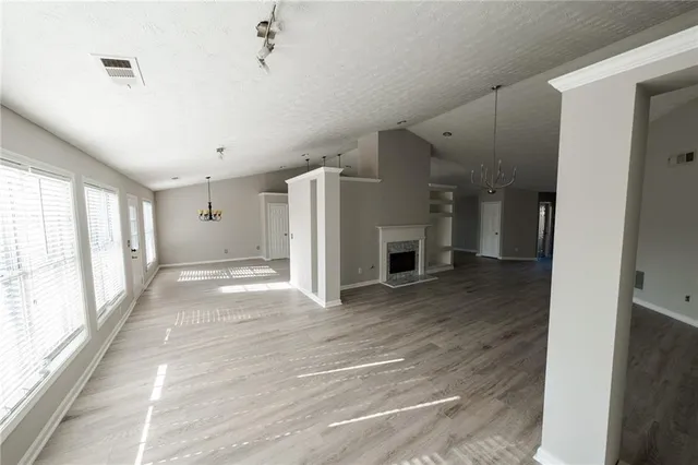 a view of a hallway with wooden floor and a living room