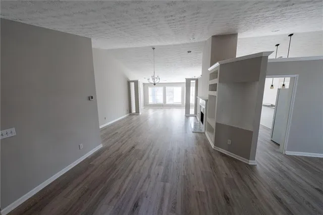 a view of a kitchen with wooden floor and a refrigerator