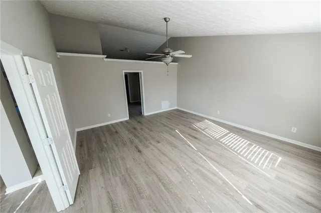 a view of a room with wooden floor and white walls