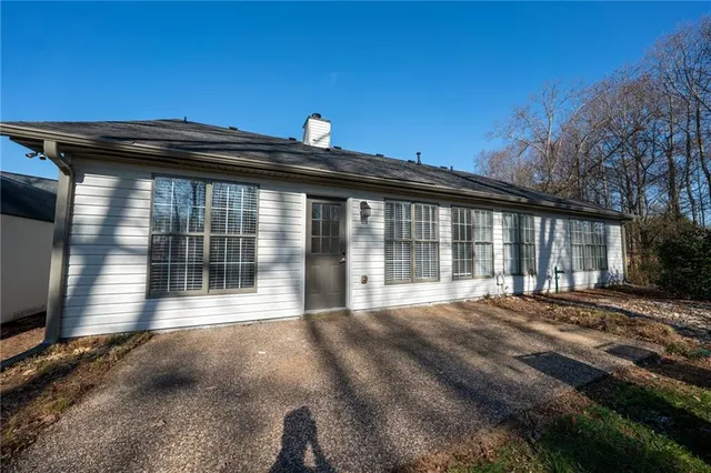 a view of house with backyard and glass windows