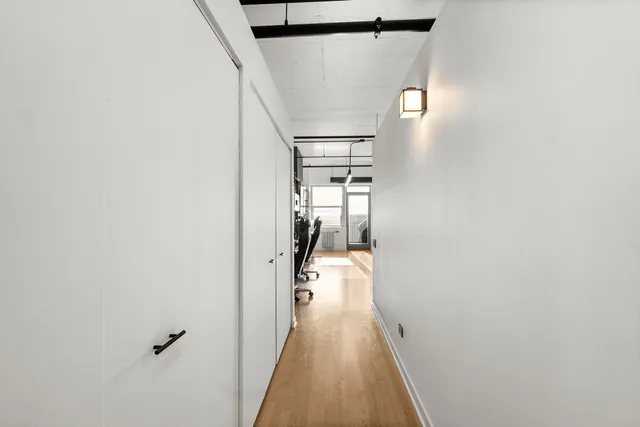 a view of a hallway with wooden floor and staircase