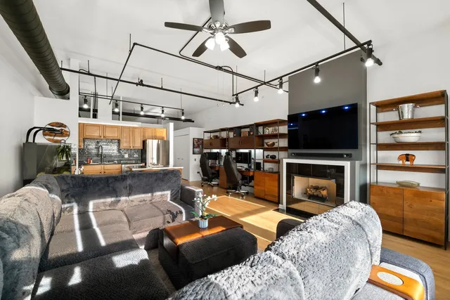 a living room with furniture a flat screen tv and a fireplace