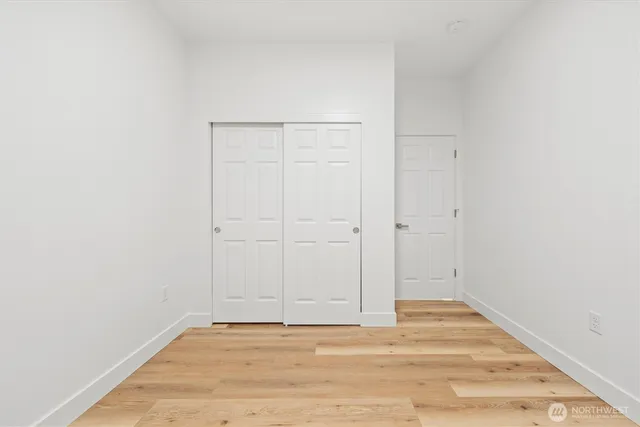 a view of an empty room with wooden floor