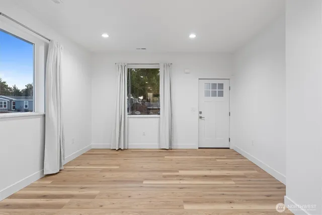 a view of a livingroom with wooden floor and front door