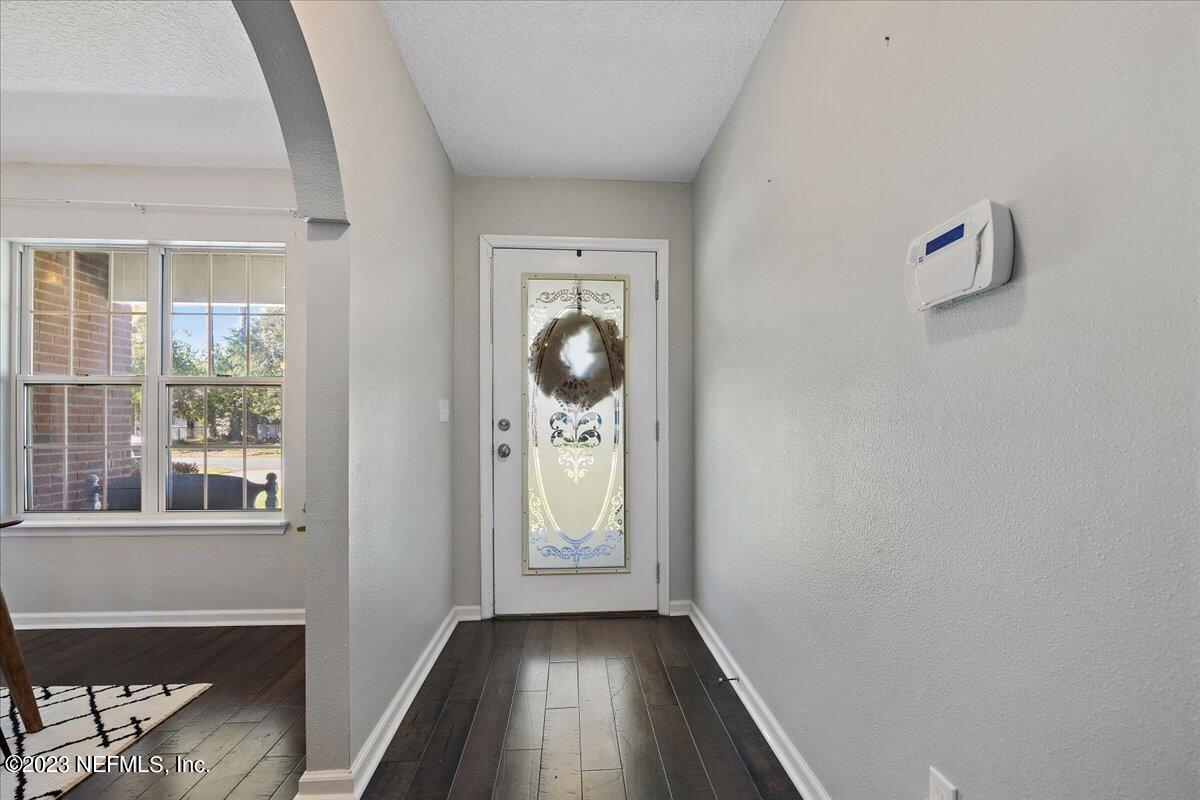 369 Owen Acres Drive Macclenny, FL 32063 - Photo 3 of 21 an empty room with wooden floor cabinet and windows