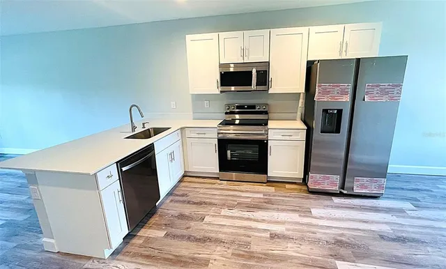 a kitchen with sink refrigerator and microwave
