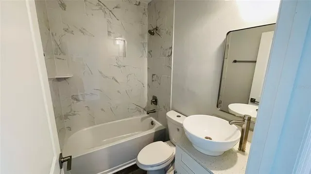 a bathroom with a toilet a sink and bathtub