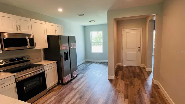 a kitchen with a refrigerator stove and wooden cabinets