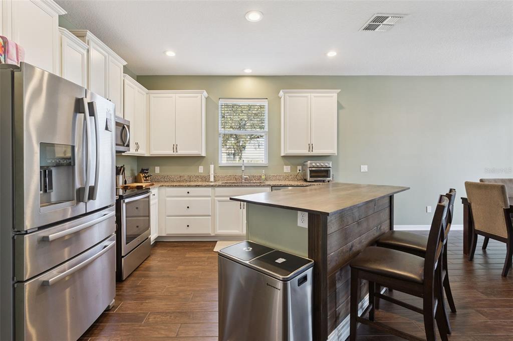 2400 Artist Point Court Apopka, FL 32703 - Photo 11 of 50 a kitchen with white cabinets and stainless steel appliances