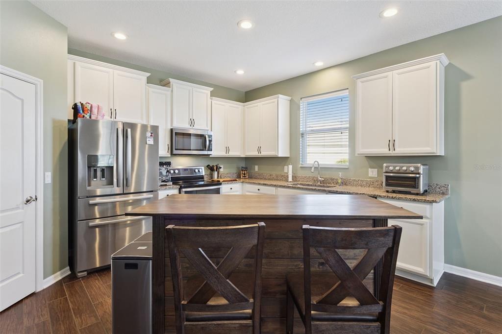 2400 Artist Point Court Apopka, FL 32703 - Photo 14 of 50 a kitchen with a table chairs refrigerator and microwave