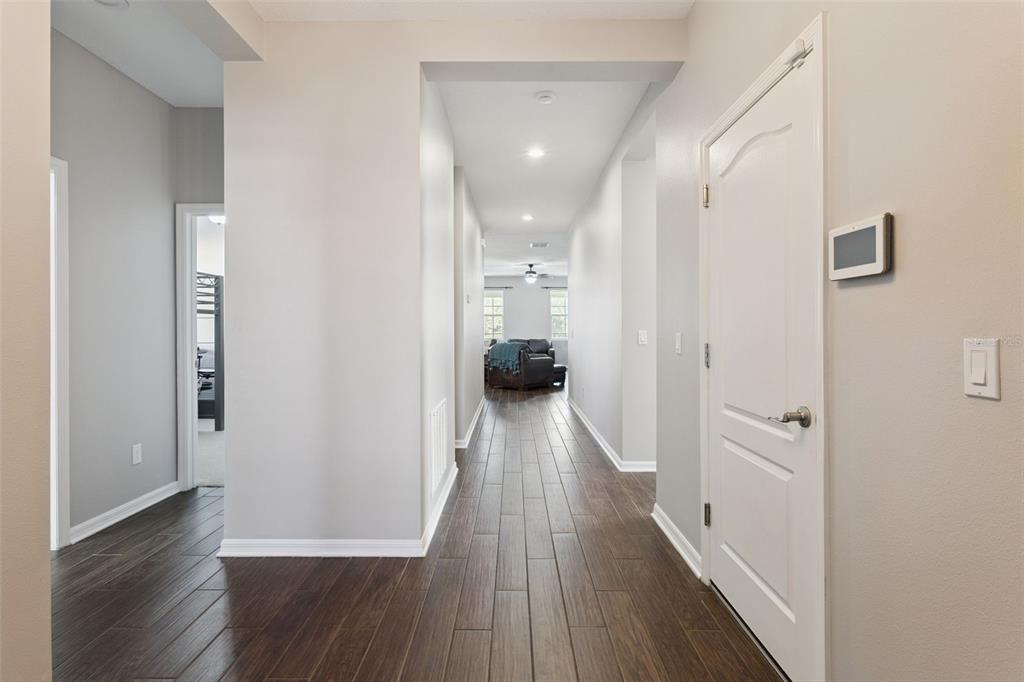 2400 Artist Point Court Apopka, FL 32703 - Photo 4 of 50 a view of a hallway with wooden floor and a bathroom