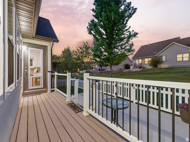 6242 Apollo Way Highland, UT 84003 - Photo 39 of 47 Expansive composite deck featuring a white and black railing system, a glass-paneled exterior door, and a white picket fence enclosing a concrete patio